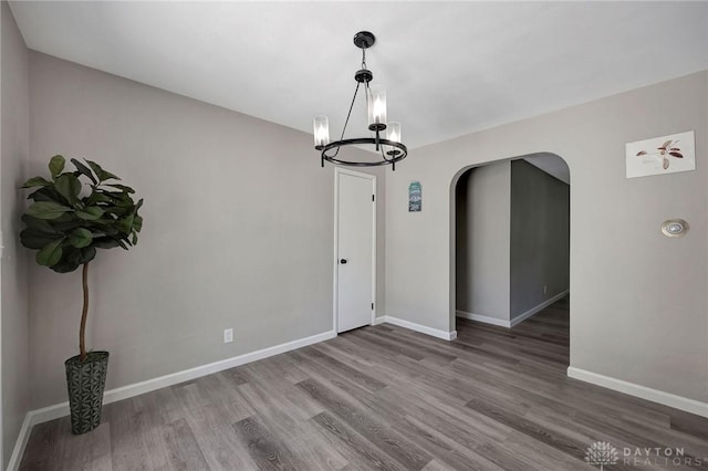 unfurnished dining area with hardwood / wood-style flooring and a notable chandelier