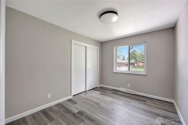 unfurnished bedroom featuring light hardwood / wood-style flooring and a closet