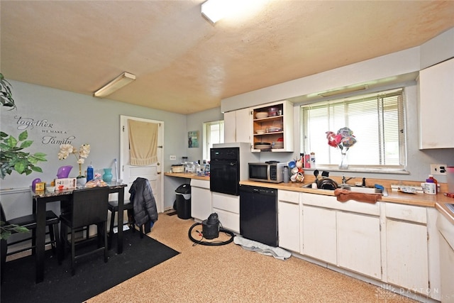 kitchen with sink, dishwasher, white cabinets, and light carpet