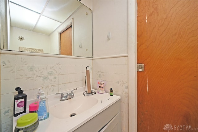 bathroom with backsplash, vanity, and tile walls