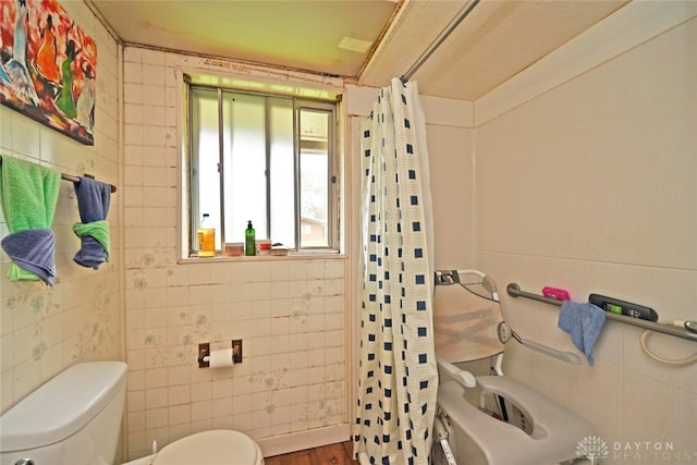 bathroom with hardwood / wood-style floors, toilet, and tile walls