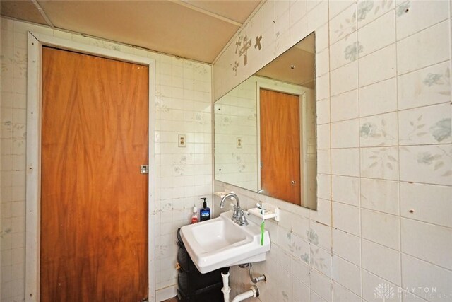 bathroom featuring tile walls and sink