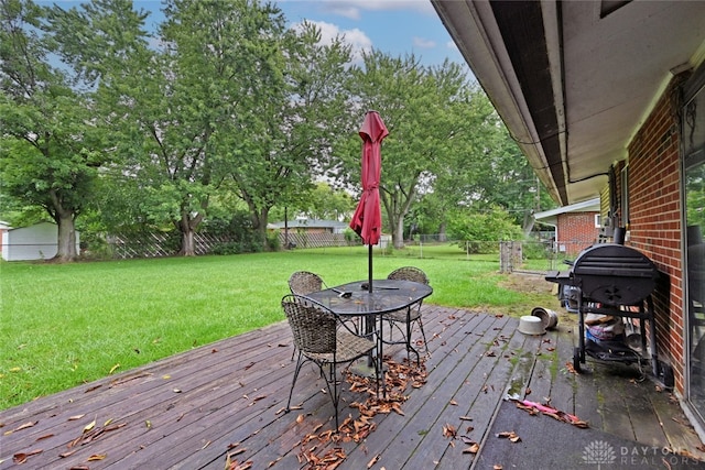 wooden deck featuring grilling area and a yard