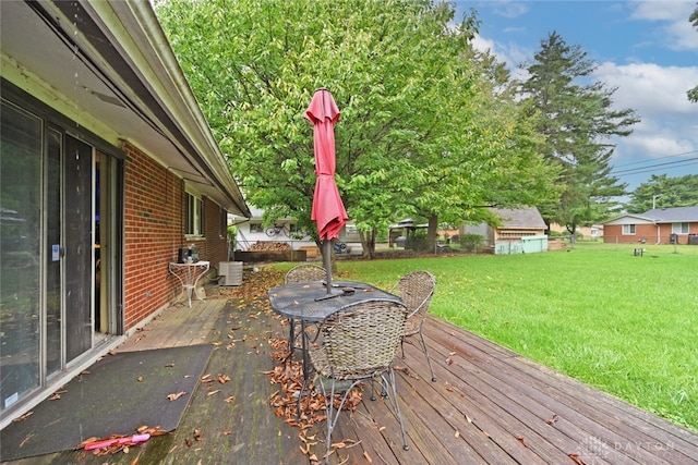 wooden deck featuring central AC unit and a lawn