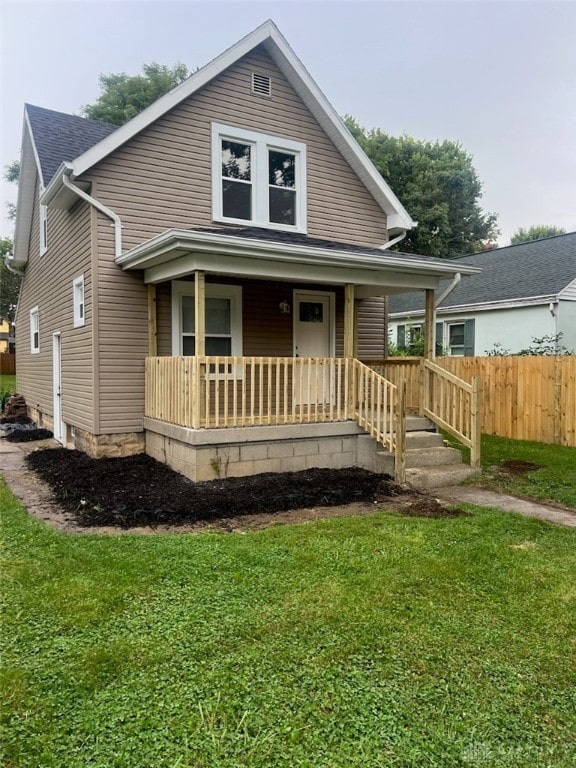 bungalow featuring covered porch and a front lawn