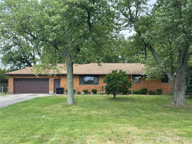 ranch-style house with a garage and a front lawn