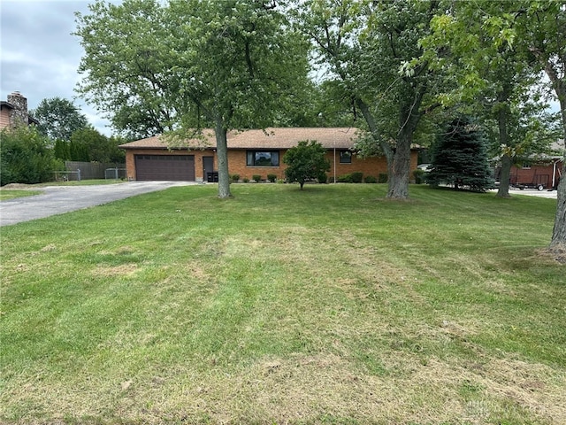 ranch-style house featuring a garage and a front lawn