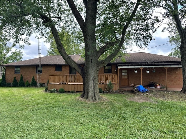 rear view of house with a wooden deck and a lawn