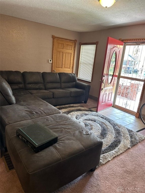 living room with a textured ceiling and light tile patterned floors