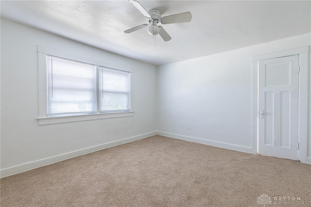 carpeted spare room with ceiling fan