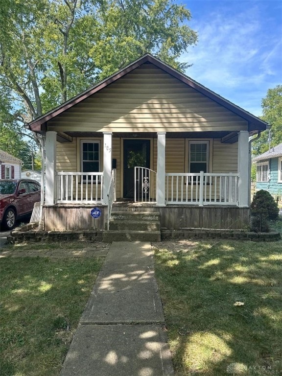 bungalow with a front lawn and covered porch