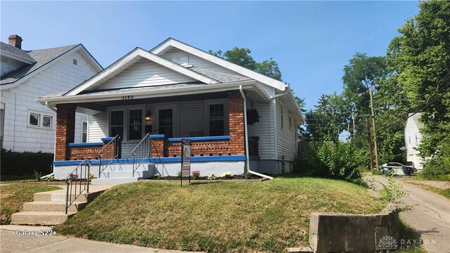 bungalow-style home with a porch and a front yard