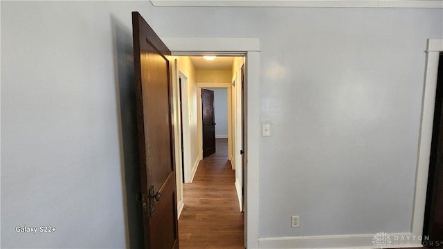 hall featuring baseboards and wood finished floors