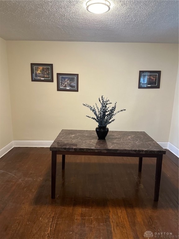 unfurnished dining area with a textured ceiling and hardwood / wood-style floors