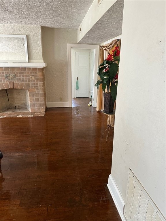 corridor with hardwood / wood-style flooring and a textured ceiling