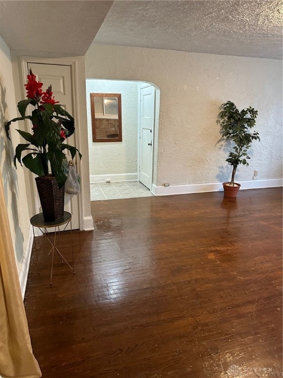 unfurnished room with a textured ceiling and hardwood / wood-style floors