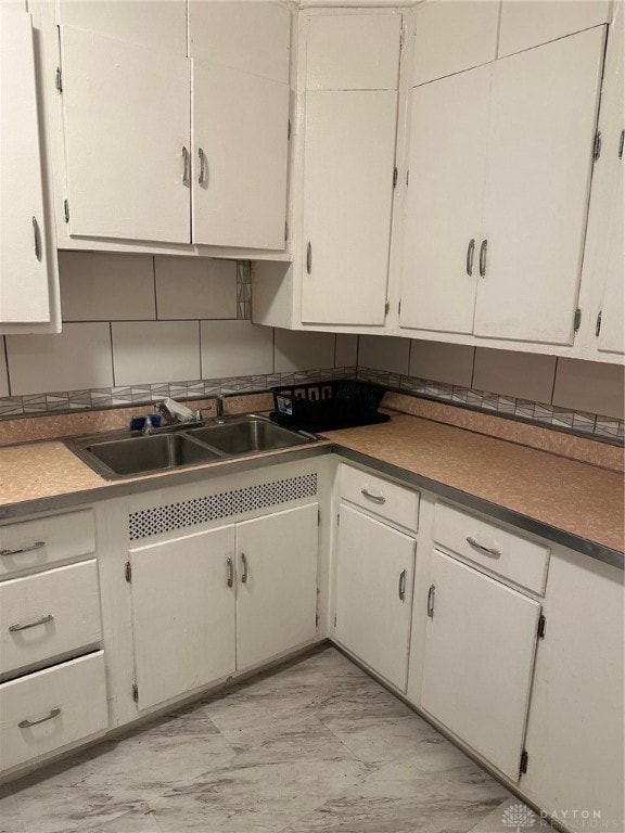 kitchen featuring white cabinetry, sink, and light tile patterned floors