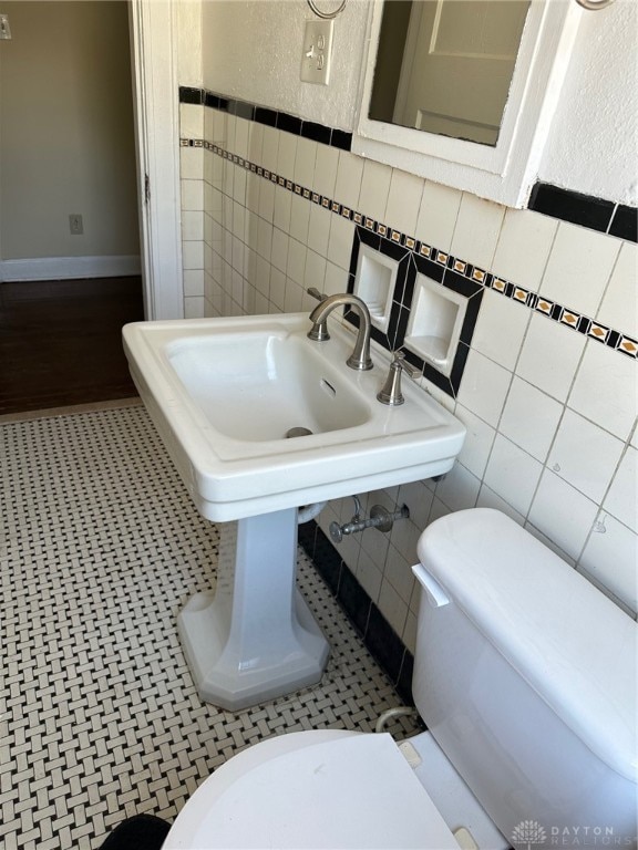 bathroom with tile patterned floors, tile walls, and toilet