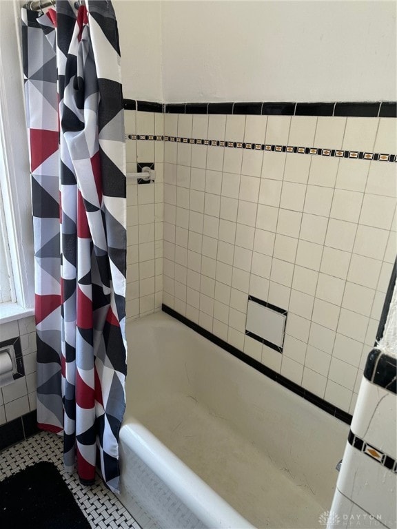 bathroom featuring tile patterned floors, tile walls, and shower / tub combo with curtain