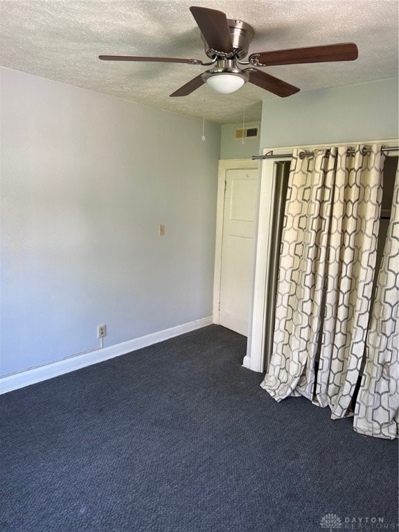 unfurnished bedroom with ceiling fan, carpet, and a textured ceiling