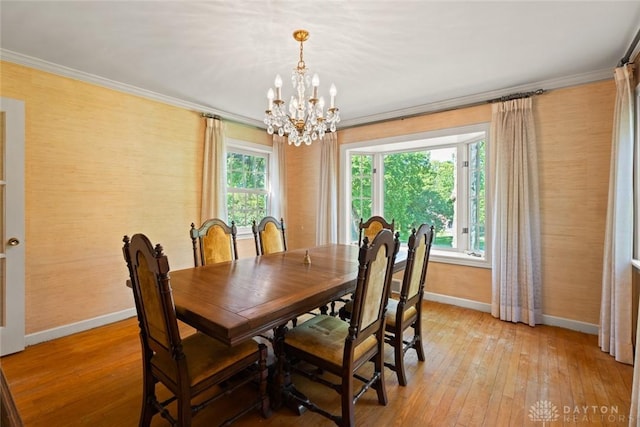 dining space featuring light wood-type flooring, plenty of natural light, baseboards, and crown molding