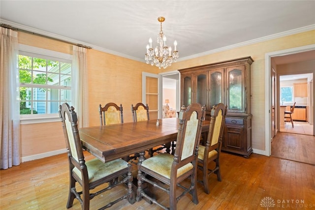 dining area with ornamental molding, plenty of natural light, and light wood-style flooring