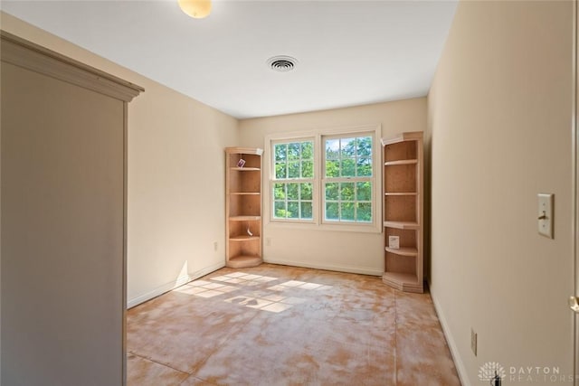 spare room featuring carpet, visible vents, and baseboards