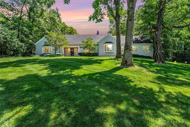 view of front of house featuring a chimney and a front lawn