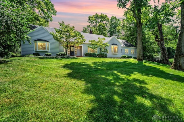 single story home featuring a lawn and a chimney