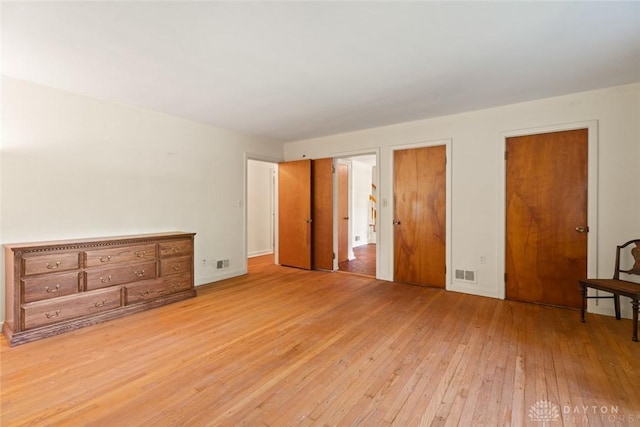 unfurnished bedroom with light wood-style flooring and visible vents