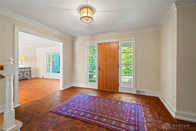 entryway with baseboards, visible vents, and crown molding