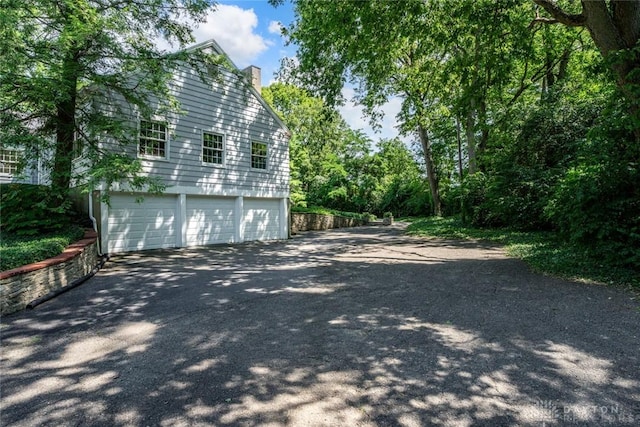 view of side of home with a garage and a chimney