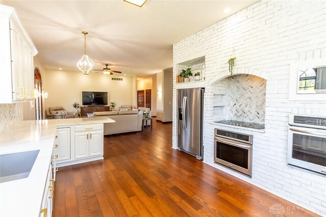 kitchen featuring appliances with stainless steel finishes, dark hardwood / wood-style flooring, white cabinetry, and ceiling fan