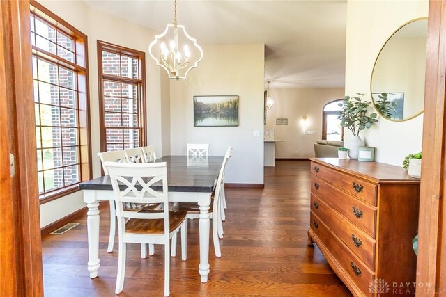 dining space featuring a notable chandelier and dark hardwood / wood-style flooring