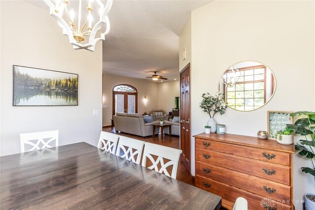 dining room featuring ceiling fan with notable chandelier and dark hardwood / wood-style floors