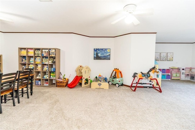 game room featuring ceiling fan, light colored carpet, and ornamental molding