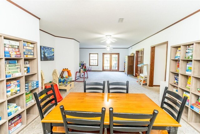 carpeted dining space with ceiling fan and french doors