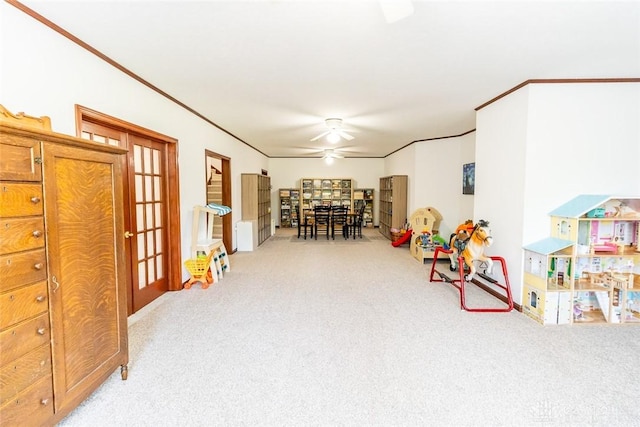 recreation room with crown molding, french doors, ceiling fan, and light colored carpet