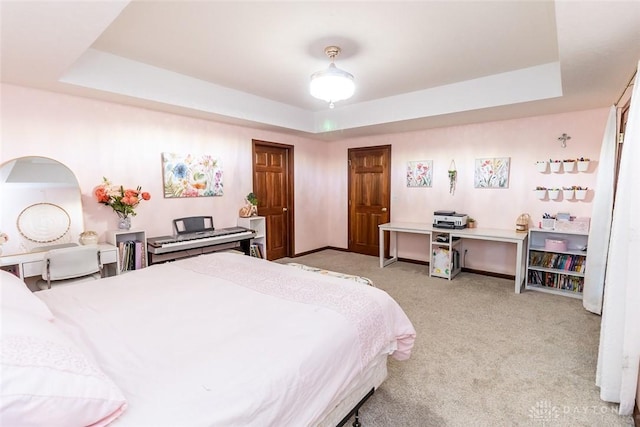 bedroom with light carpet and a tray ceiling