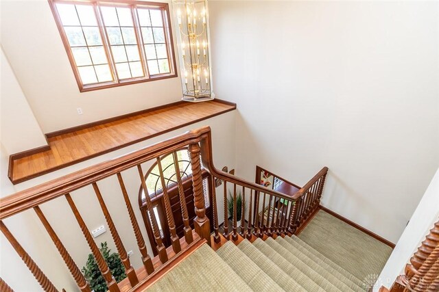 stairs featuring a chandelier and wood-type flooring