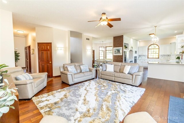 living room featuring ceiling fan and dark wood-type flooring