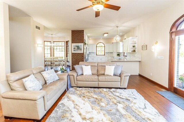 living room with ceiling fan and dark hardwood / wood-style flooring