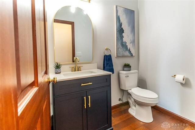 bathroom with toilet, vanity, and hardwood / wood-style flooring