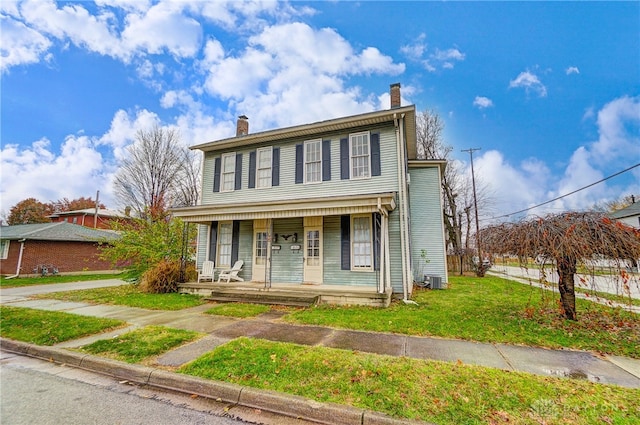 front of property with a front yard and covered porch