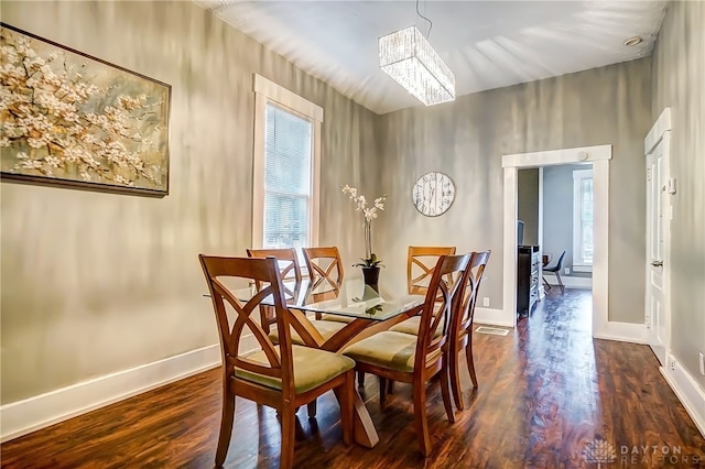 dining room with a notable chandelier and dark hardwood / wood-style flooring