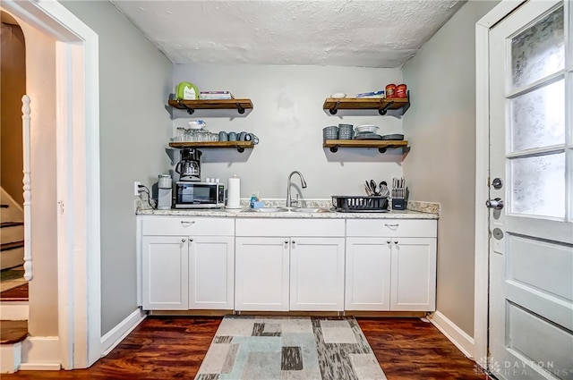 bar with sink, dark hardwood / wood-style flooring, plenty of natural light, and white cabinets