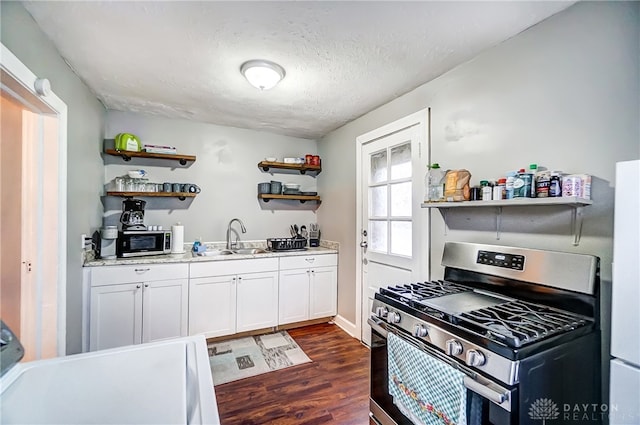 kitchen with stainless steel appliances, sink, a textured ceiling, white cabinets, and dark hardwood / wood-style flooring