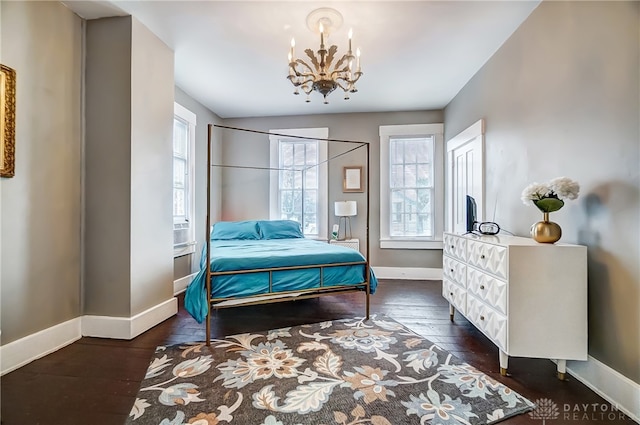 bedroom featuring a notable chandelier and dark wood-type flooring