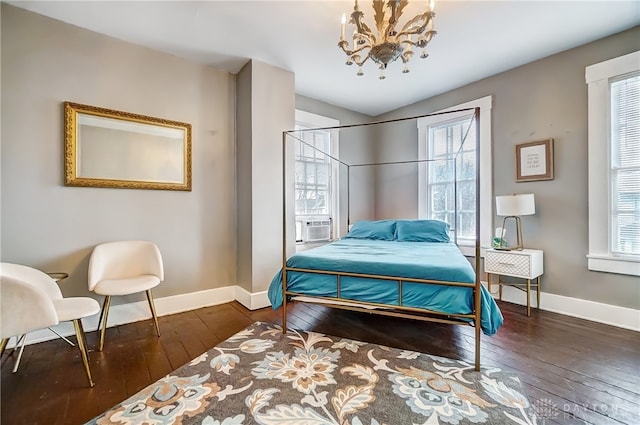 bedroom with a chandelier, dark wood-type flooring, and multiple windows