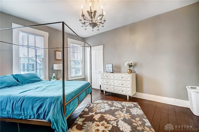 bedroom featuring an inviting chandelier and dark hardwood / wood-style floors